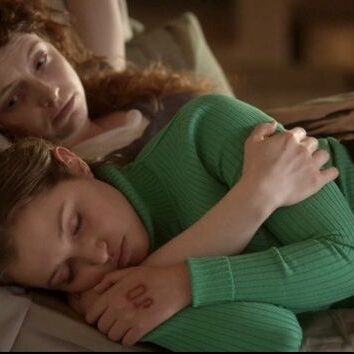 Meredith holds Mia while she sleeps in the hospital bed